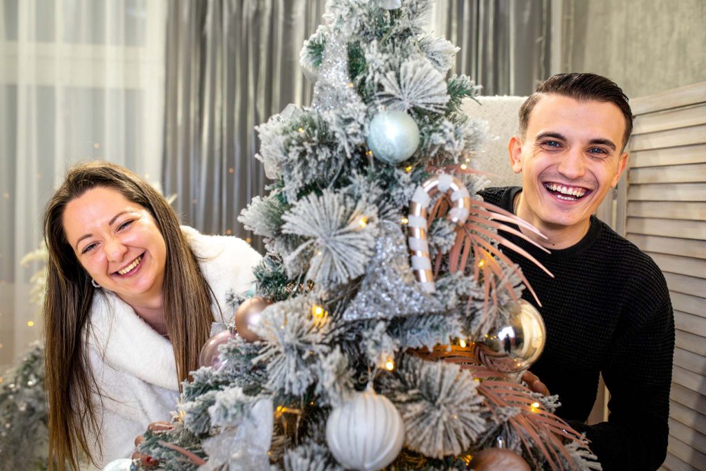 Karácsonyi páros fotózás Budapesten – Kristóf és Daniella a fa mögött